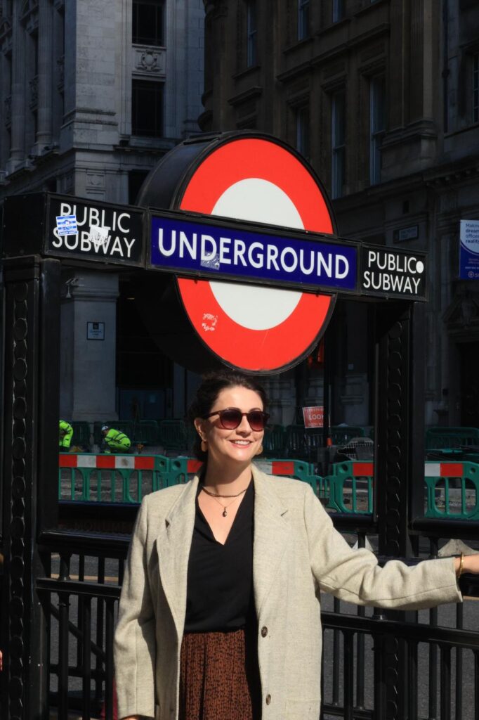 Juliana na entrada de uma estação de metrô em Londres. Transporte em Londres.